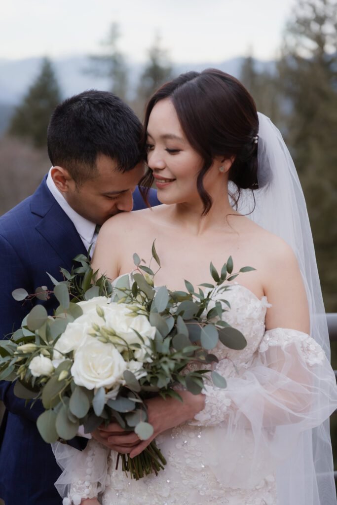 Elegant wedding bouquet made of white roses and lush greenery.