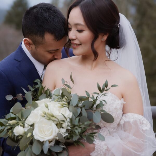 Elegant wedding bouquet made of white roses and lush greenery.