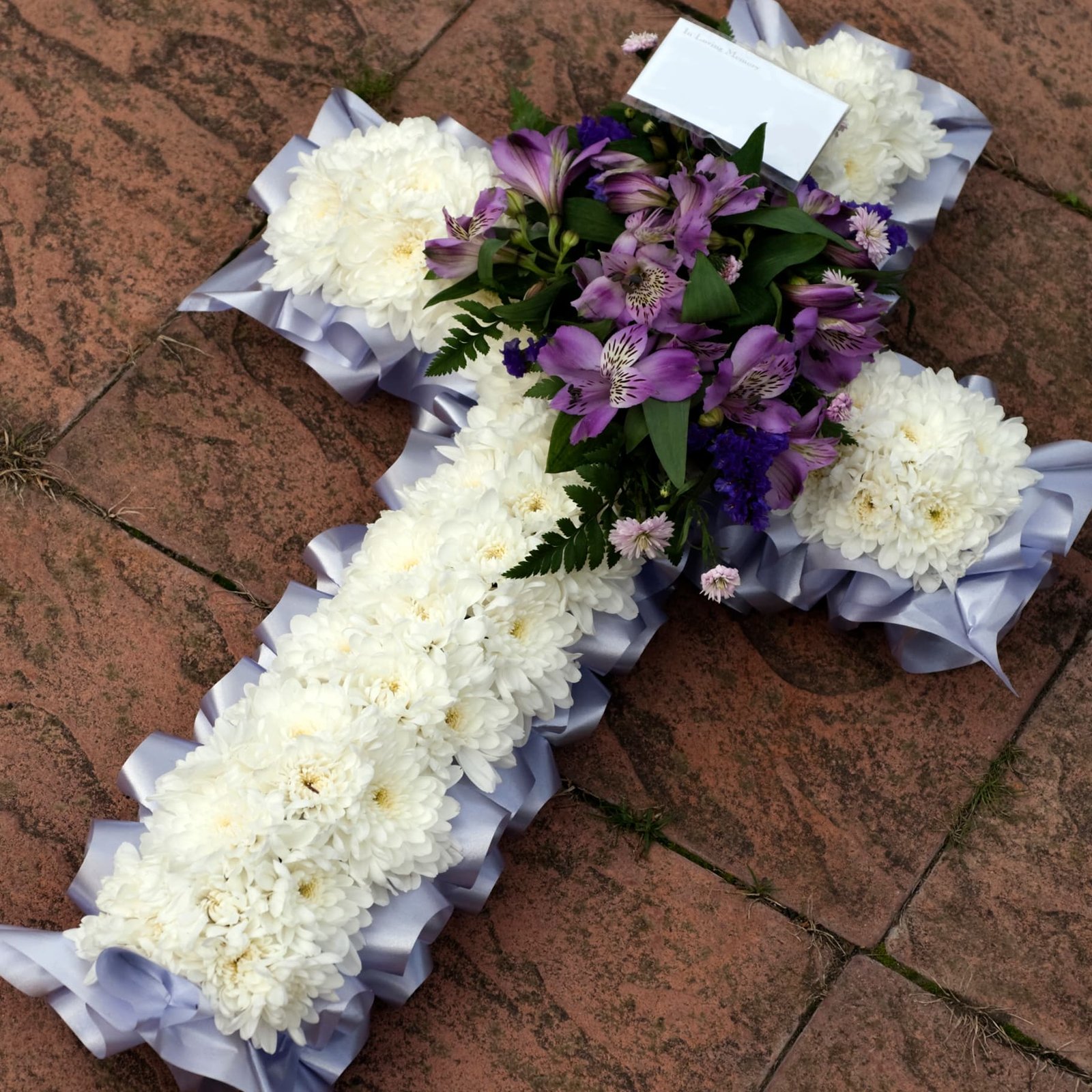 cross funeral wreath with delicate blooms created by a Surrey florist providing funeral flowers Surrey