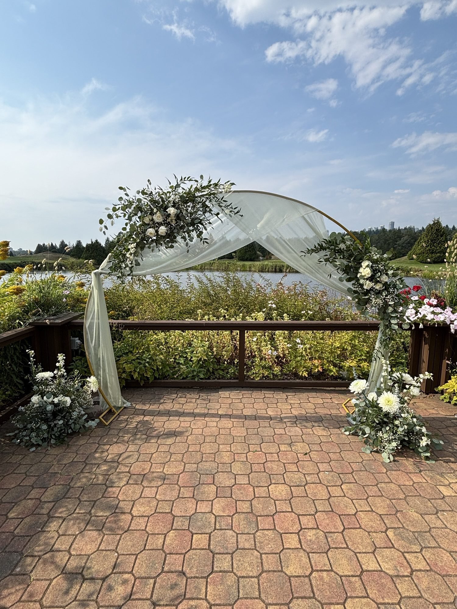 Wedding arch decorated with roses and greenery, created by a Surrey wedding florist for an outdoor ceremony.