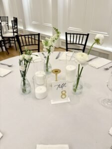 Minimal bud vase arrangements featuring white roses, ranunculus, and snapdragons.