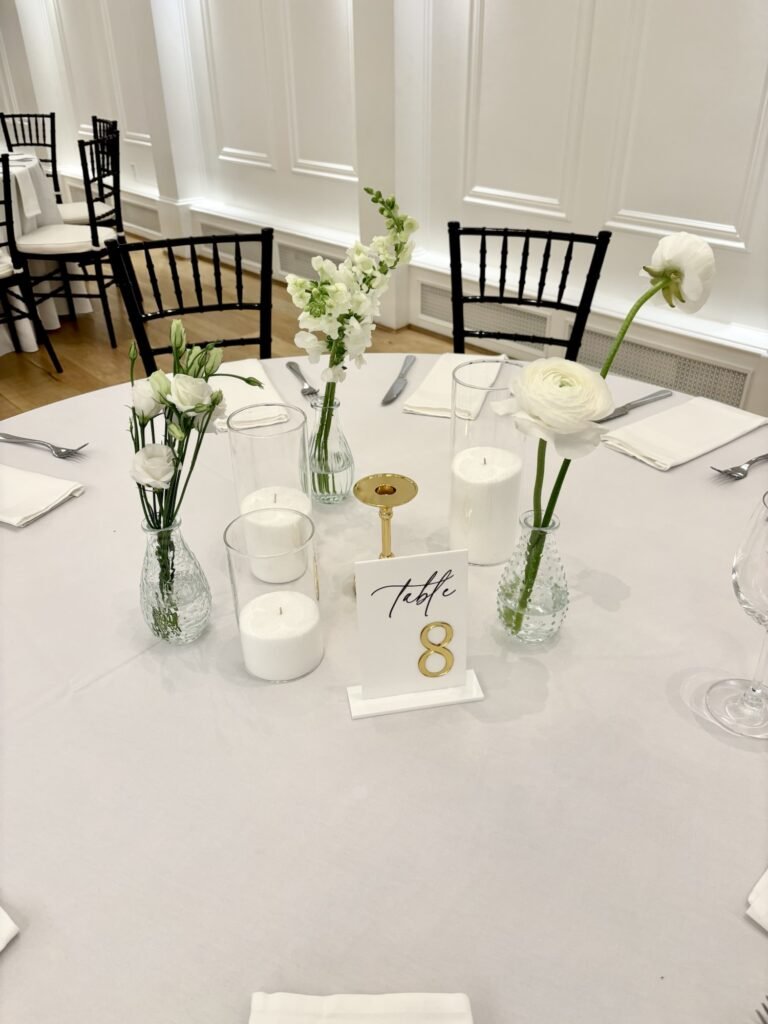 Minimal bud vase arrangements featuring white roses, ranunculus, and snapdragons.