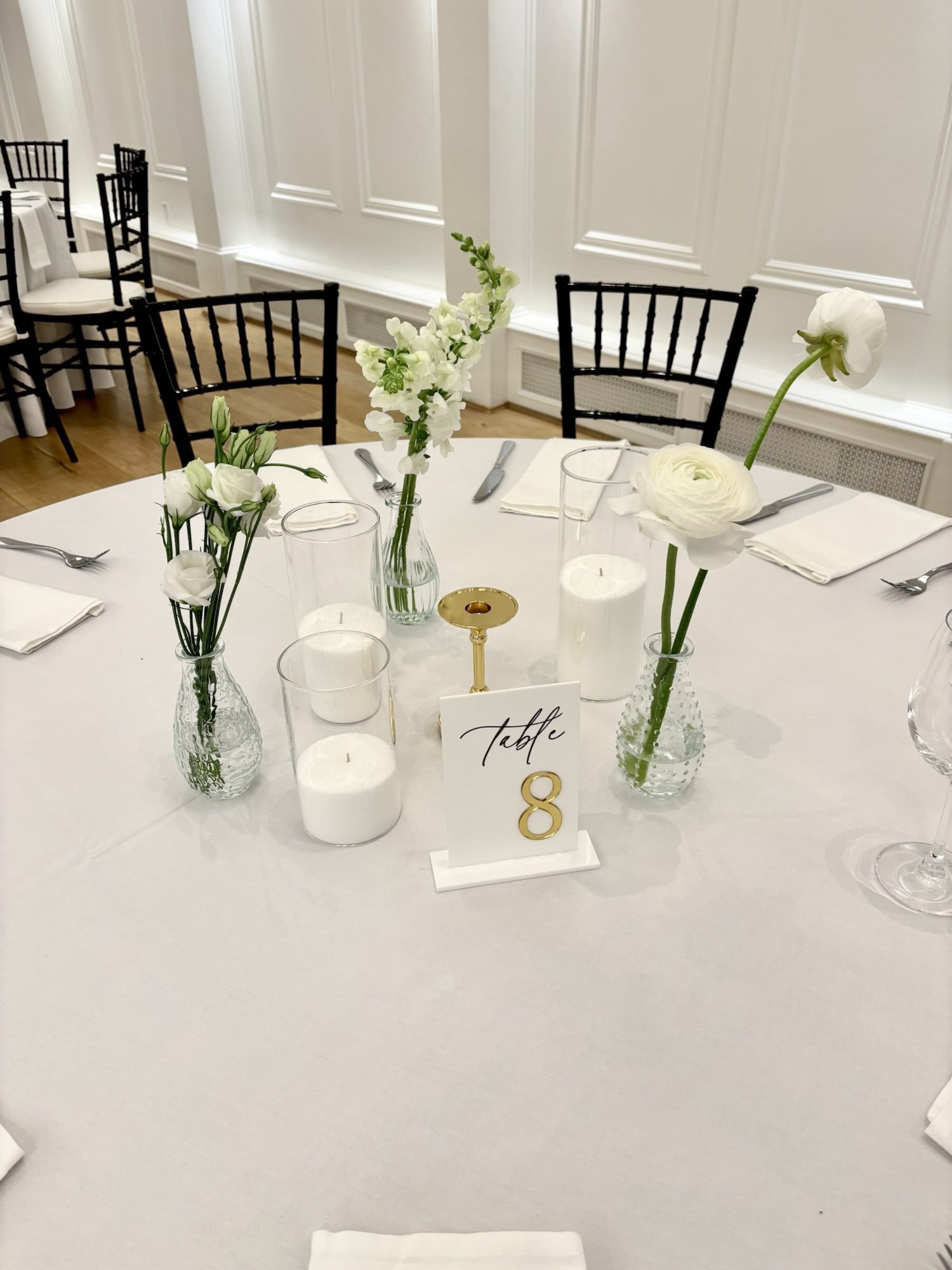 Minimal bud vase arrangements featuring white roses, ranunculus, and snapdragons.