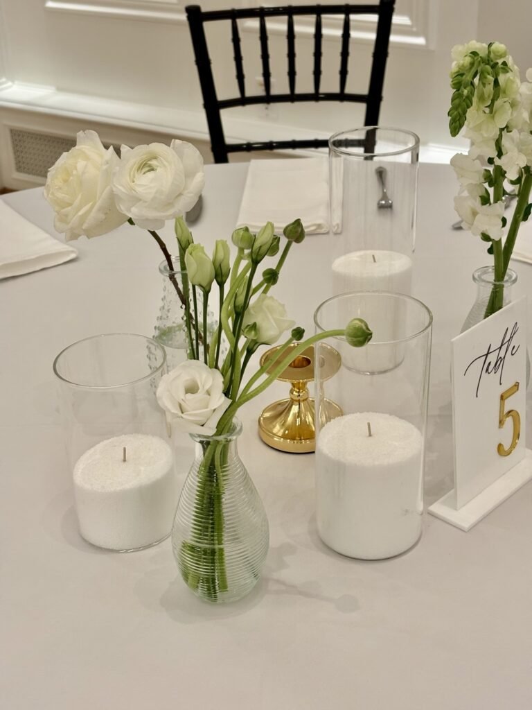 Minimalist white and green bud vase arrangements created by a Surrey wedding florist for modern wedding décor
