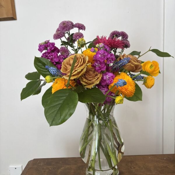 vase of colorful flowers including roses, ranunculus, stock, and chrysanthemums. Available for delivery in Surrey BC by Petal & Bulb florists.